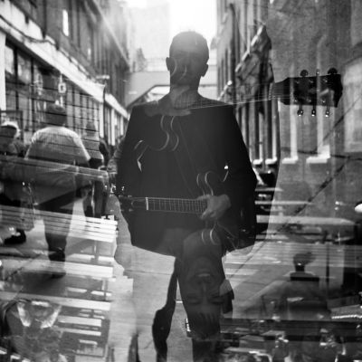 Chris Allard, staff at Guildhall School of Music & Drama, black and white photo of Chris standing in street with artistic blur of passers-by